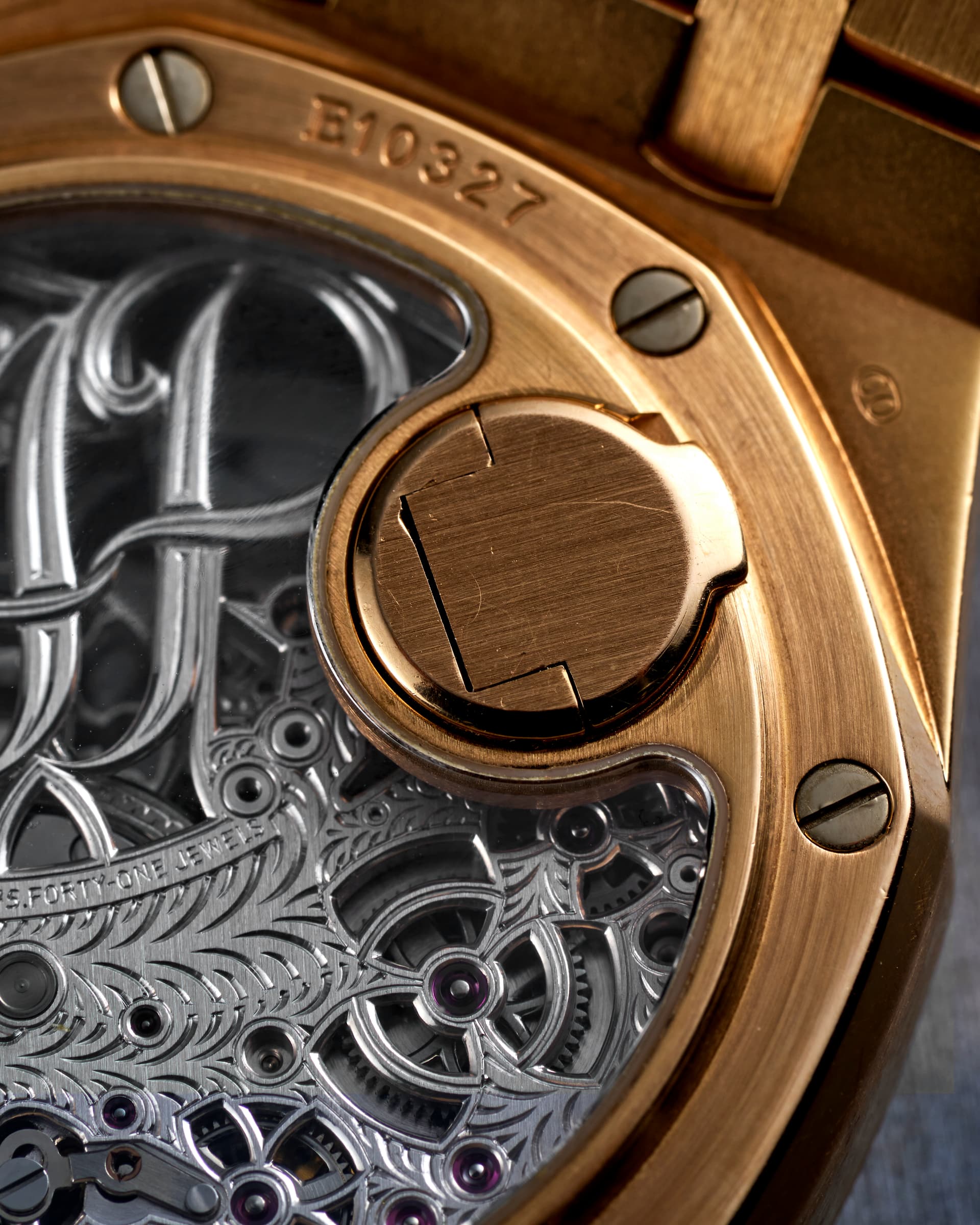 Audemars Piguet Royal Oak Tourbillon Squelette, yellow gold — Macro on the hand engraving — a continuous pattern cut across separate components.