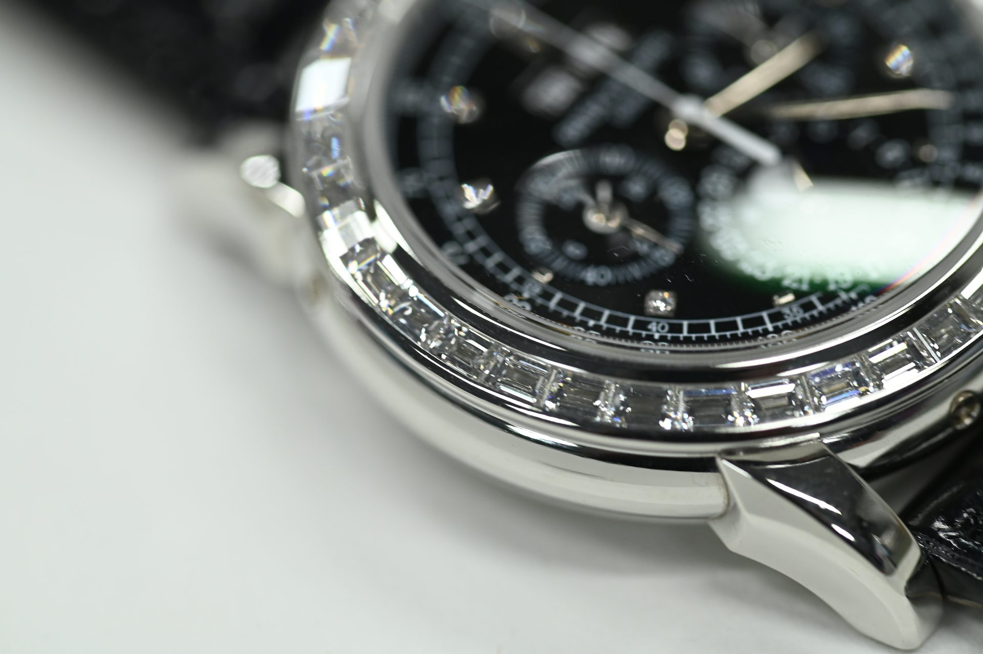 Patek Philippe Perpetual Calendar Chronograph, diamond-set — Black dial perpetual calendar chronograph in white gold under a baguette-cut diamond bezel.